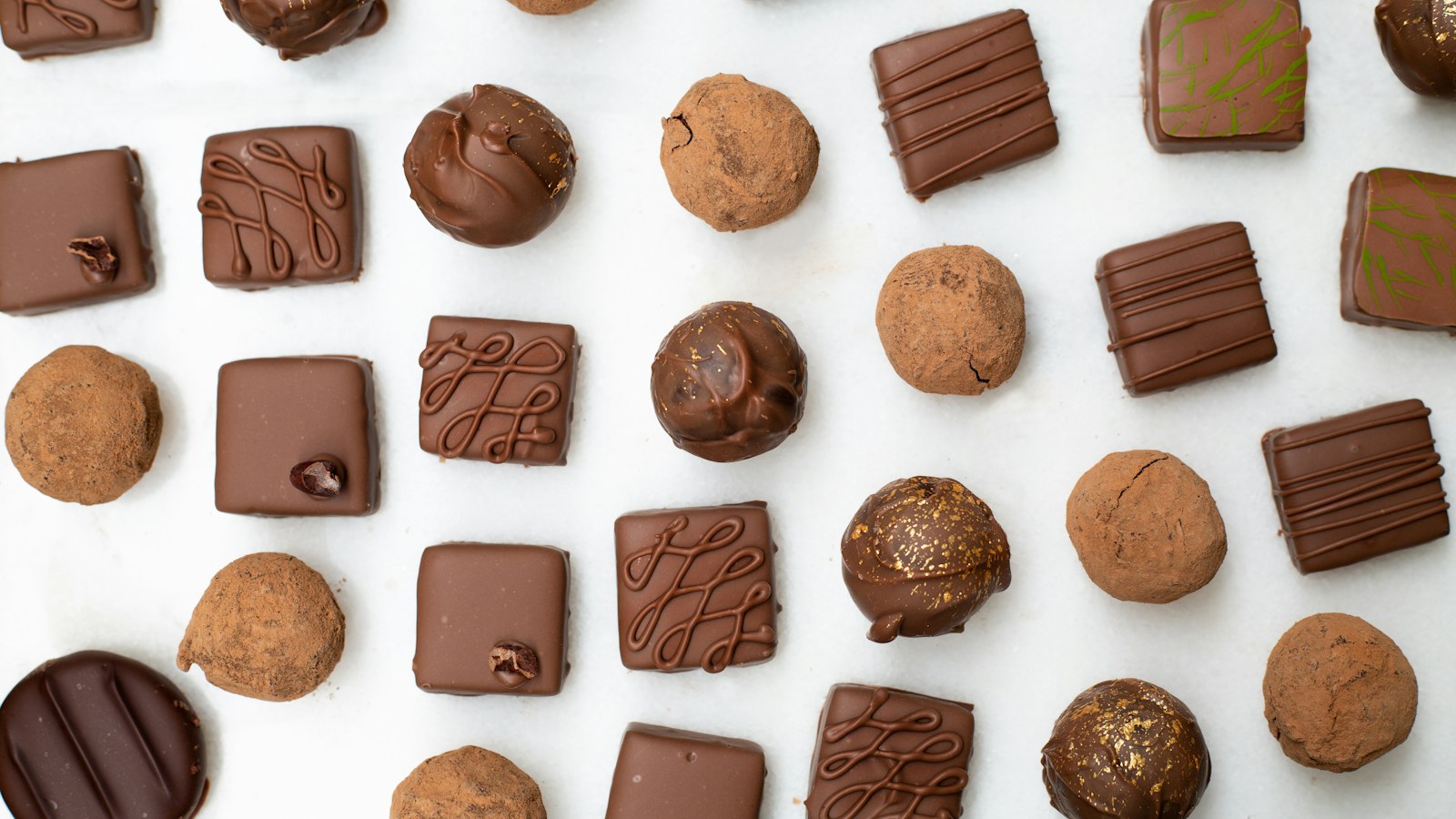 Palline al cacao e cioccolatini disposti su un fondo bianco