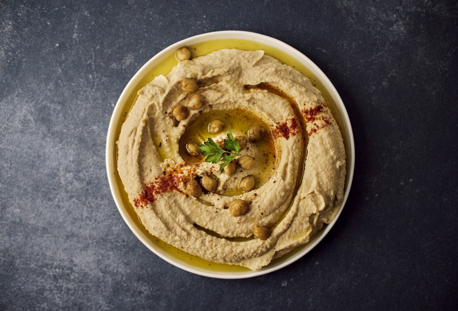 Piatto di hummus con olio extravergine, paprika e ceci