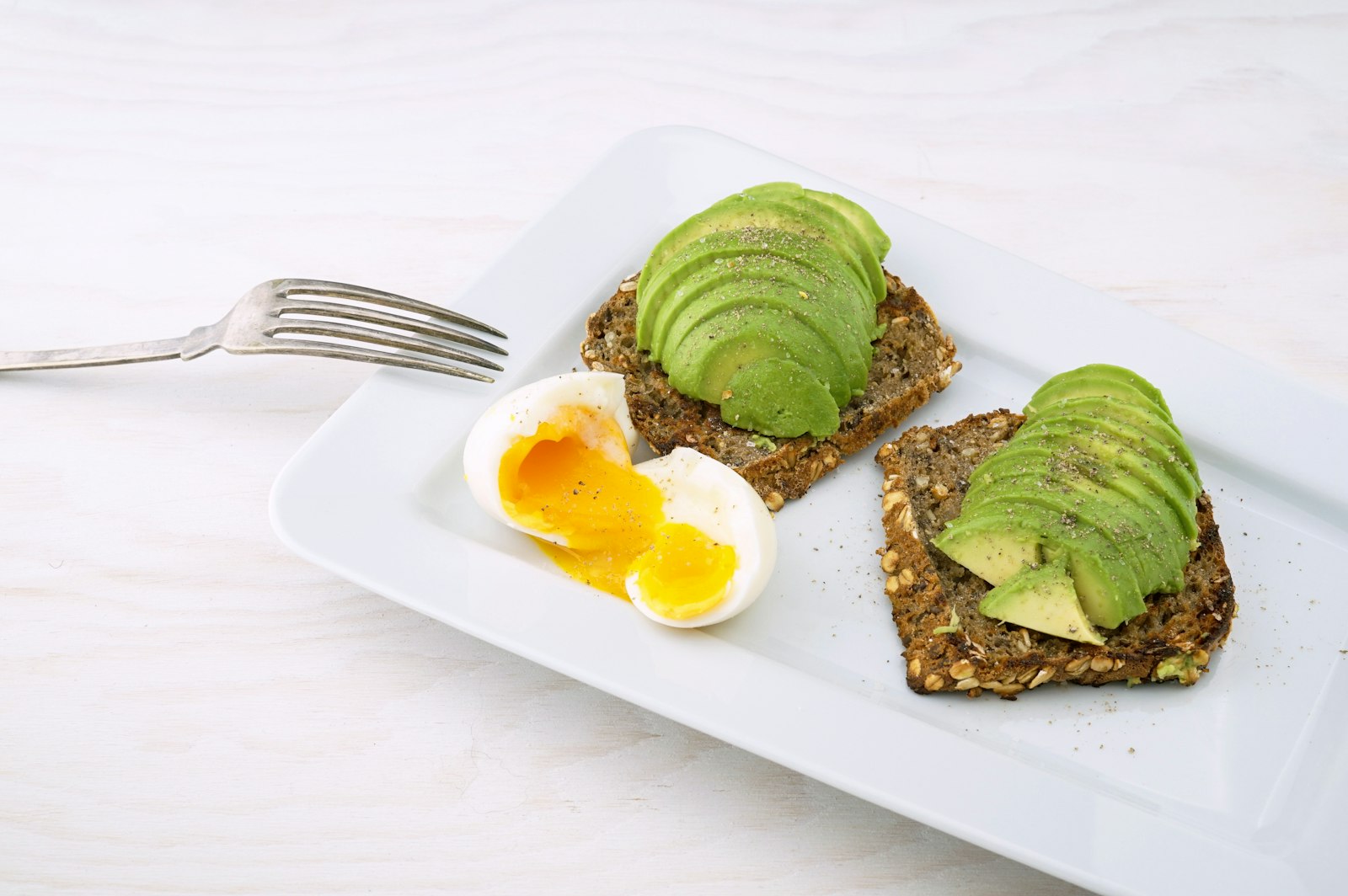 Fette di pane integrale con avocado e uovo alla coque
